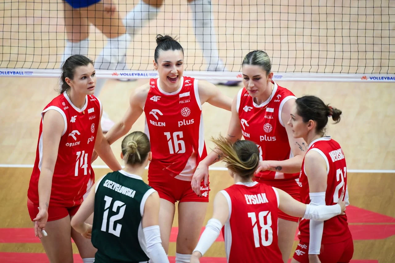 Reprezentacja Polski siatkarek znakomicie radzi sobie w Lidze Narodów 2026 Grupa polskich siatkarek w czerwonych strojach gromadzi się na boisku, skoncentrowana i gotowa do gry, pośród nich libero w zielonym stroju.