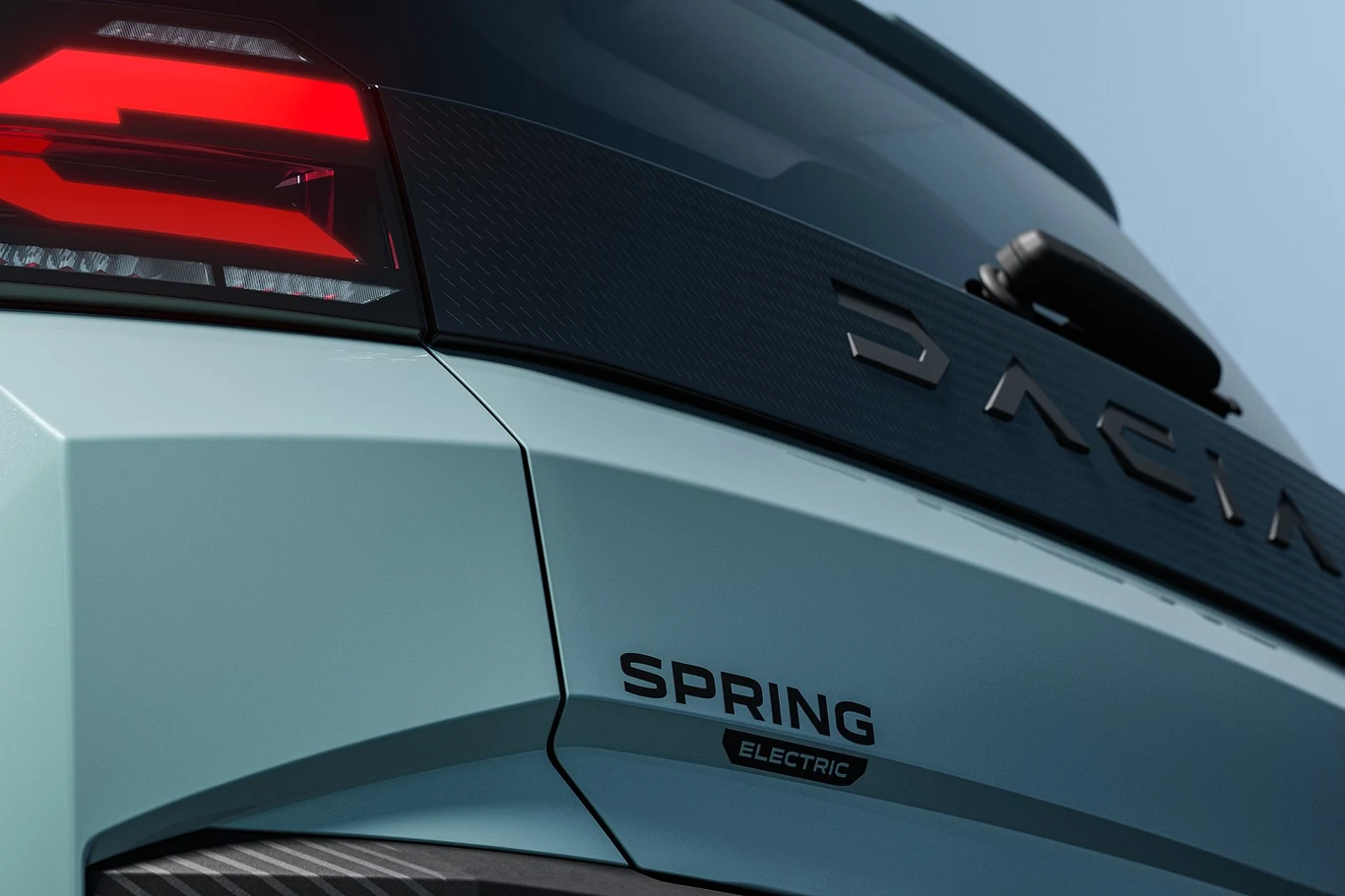 Tylna część nadwozia Dacii Spring Electric z widocznym logo marki oraz nazwą modelu pod tylną szybą, czerwonym światłem lampy i delikatnie zarysowaną linią klapy bagażnika.