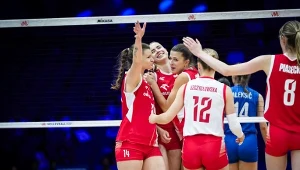Zawodniczki drużyny siatkarskiej w czerwono-białych strojach świętują zdobycie punktu podczas meczu na hali sportowej.