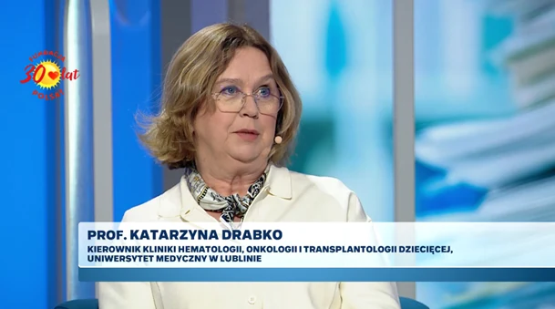 Kobieta w okularach i jasnym żakiecie udziela wywiadu w studiu telewizyjnym, obok widoczna grafika z imieniem, nazwiskiem oraz tytułem naukowym rozmówczyni.