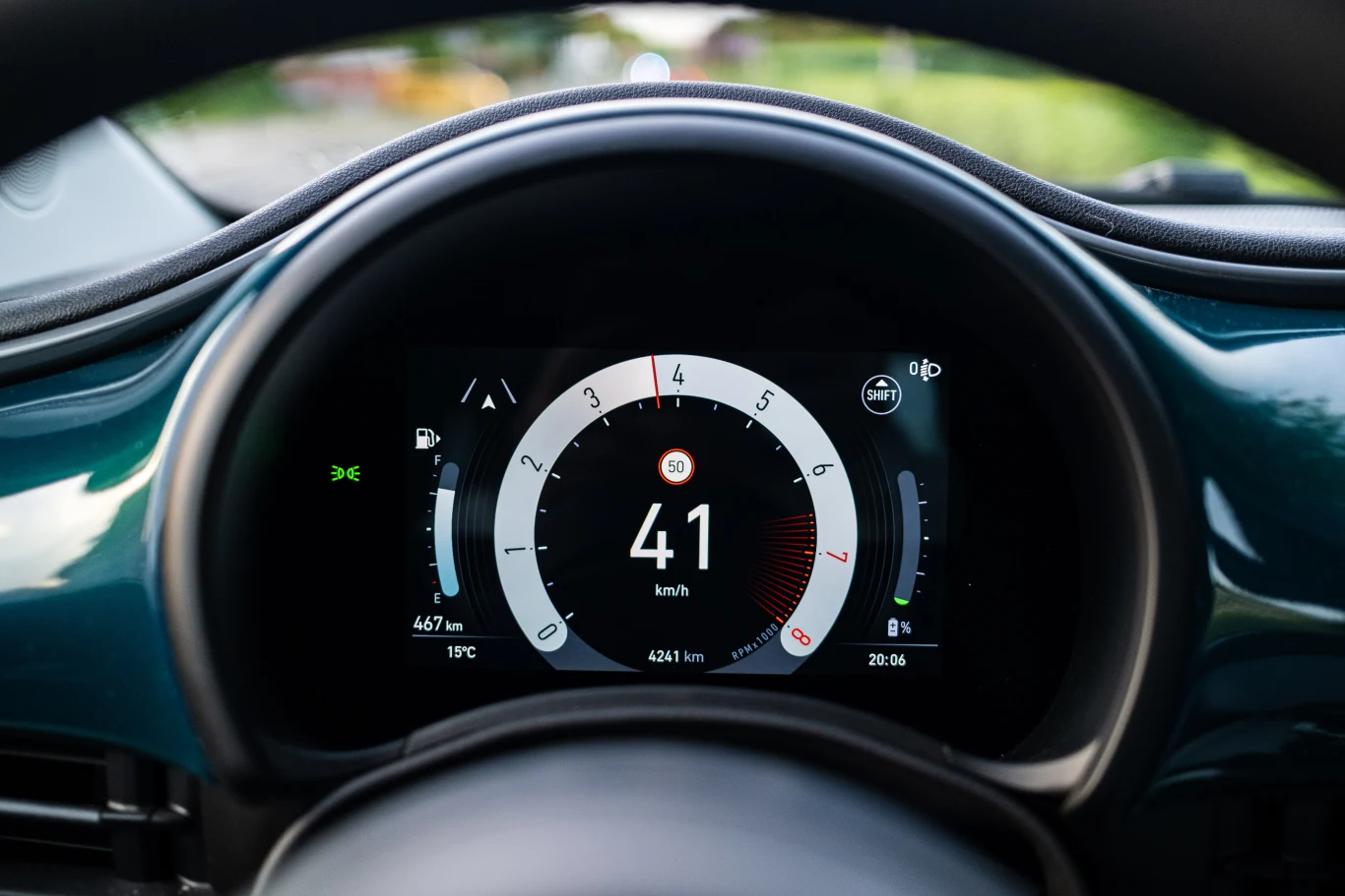 Cyfrowy wyświetlacz prędkościomierza samochodowego z dużą liczbą 41 km/h pośrodku, wskaźnikami poziomu energii i zasięgu po bokach oraz informacją o temperaturze i czasie na dole ekranu.