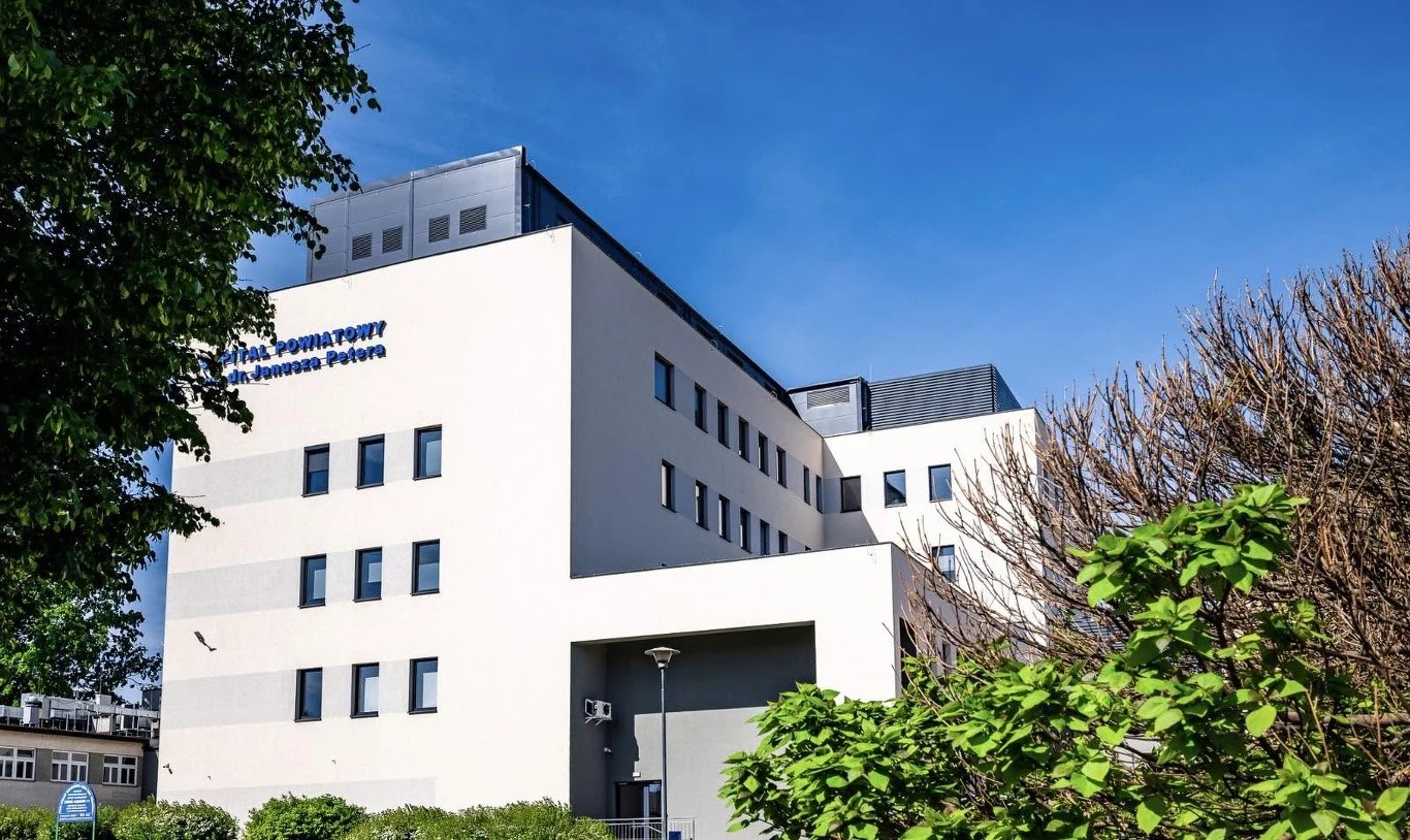 Szpital Powiatowy w Tomaszowie Lubelskim Szpital Powiatowy w Tomaszowie Lubelskim. Wielokondygnacyjny, jasny budynek z licznymi oknami, otoczony zielenią.
