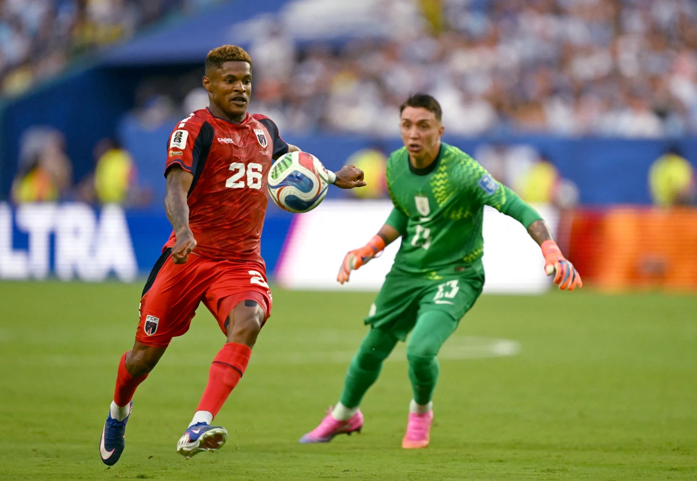 Fernando Muslera (na drugim planie) wie, że egzekucja jest przesądzona. Za chwilę Helio Varela ustali wynik spotkania na 2:2 Piłkarz w czerwonym stroju z numerem 26 prowadzi piłkę na tle bramkarza w zielonym stroju podczas meczu piłkarskiego.