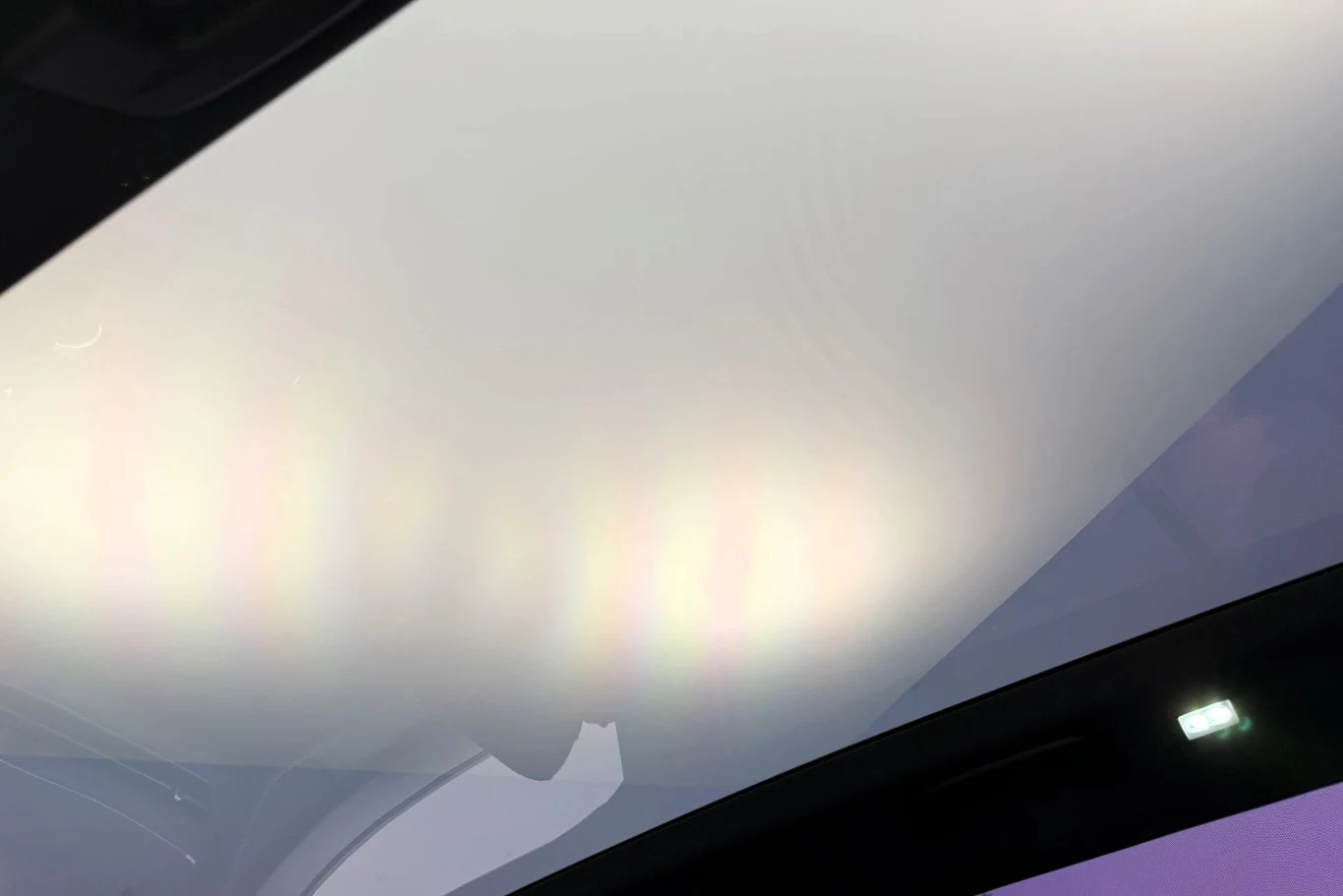 Panoramiczny dach samochodu z delikatnymi refleksami świetlnymi i subtelną poświatą na szkle.