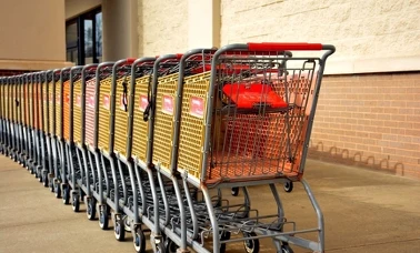Rząd sklepowych wózków przed wejściem do marketu