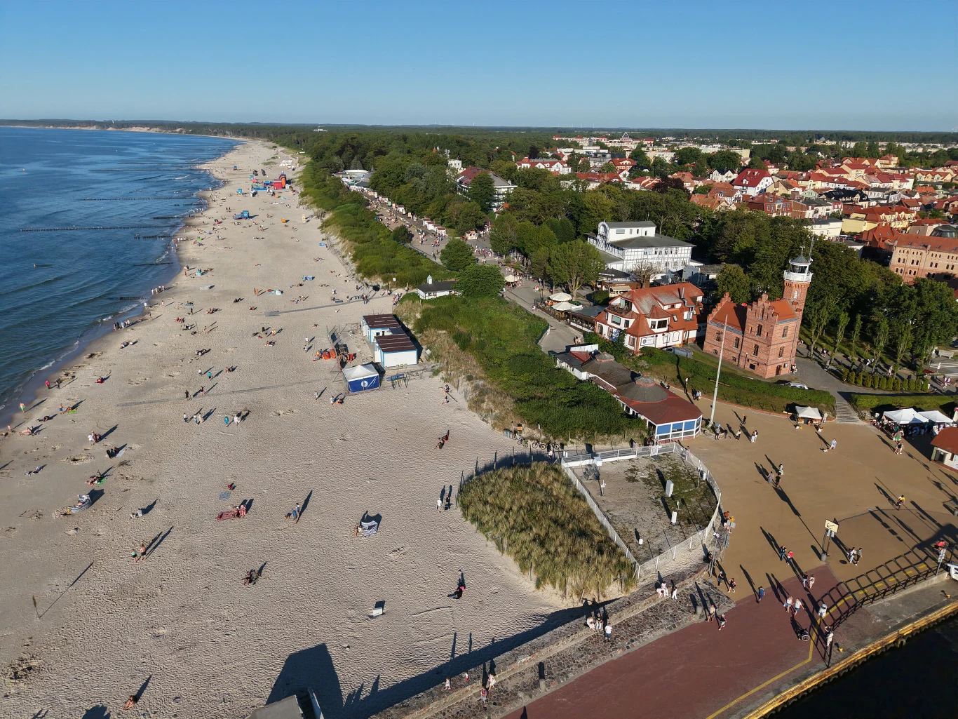 Ustka została wskazana jako perełka polskiego wybrzeża Szeroka, piaszczysta plaża z licznymi spacerującymi osobami, promenada wzdłuż wybrzeża oraz charakterystyczna czerwona wieża na tle zabudowań nadmorskiego miasteczka.