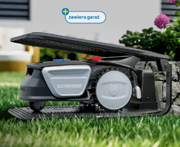 Robot koszący Sunseeker schowany w nowoczesnym garażu, otoczony zieloną trawą i elementami ogrodu.