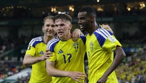 Trzech piłkarzy w żółto-niebieskich strojach reprezentacji Szwecji celebrujących razem zdobycie gola na murawie stadionu.