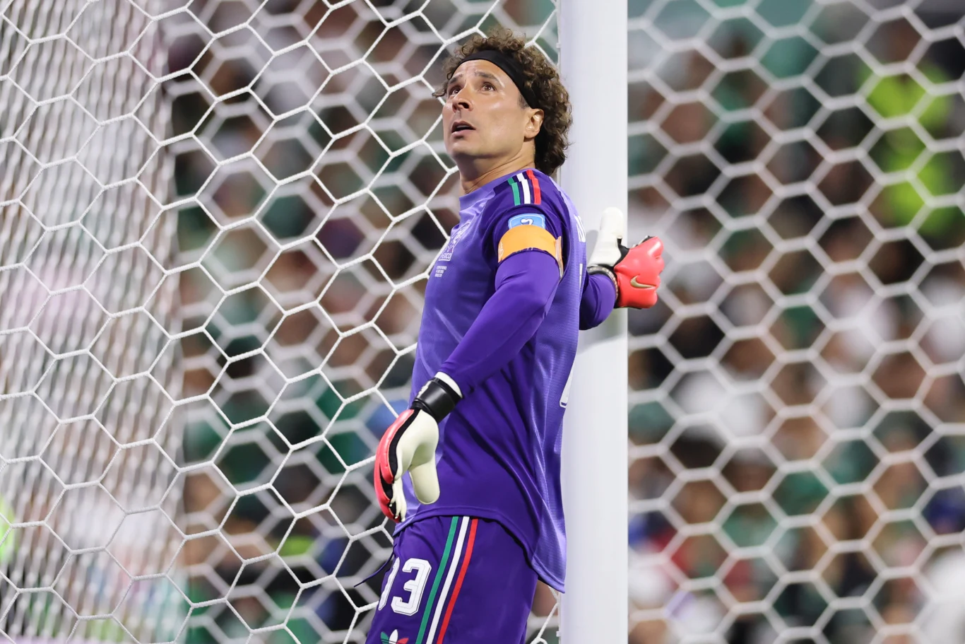 Guillermo Ochoa Guillermo Ochoa w fioletowym stroju z numerem 13 oparty o słupek bramki podczas meczu piłki nożnej.