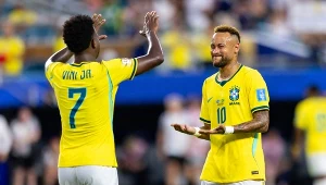 Dwóch piłkarzy reprezentacji Brazylii w żółtych koszulkach podczas celebracji na boisku, jeden z nich pokazuje numer 7 na plecach, a drugi wykonuje charakterystyczny gest rękami.