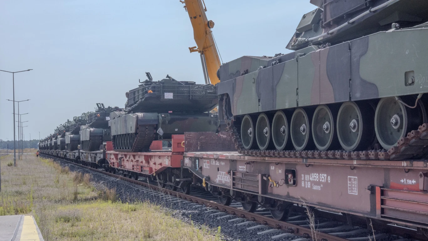 Najnowocześniejsze czołgi Abrams dotarły do Polski. Będą bronić wschodniej flanki (zdjęcie ilustracyjne). Czołgi Abrams ustawione na platformach kolejowych, transportowane przez ciężkie pociągi towarowe.