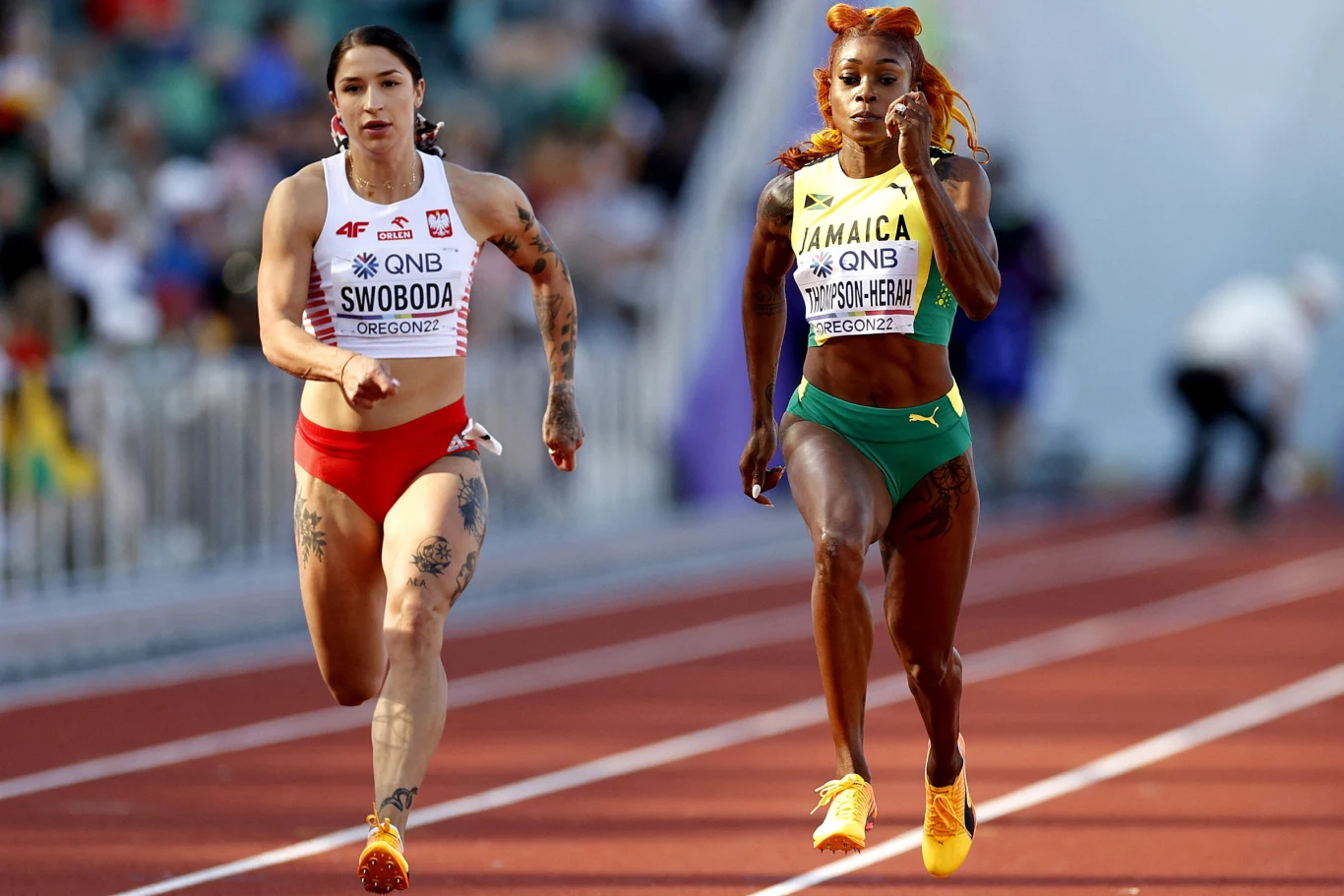 Ewa Swoboda (z lewej) i Elaine Thompson-Herah. Po raz piąty zmierzyły się na 100 metrów Dwie sprinterki w akcji podczas biegu na stadionie lekkoatletycznym, jedna w czerwonym stroju reprezentacji Polski, druga w zielono-żółtym stroju reprezentacji Jamajki, skupione w trakcie rywalizacji.