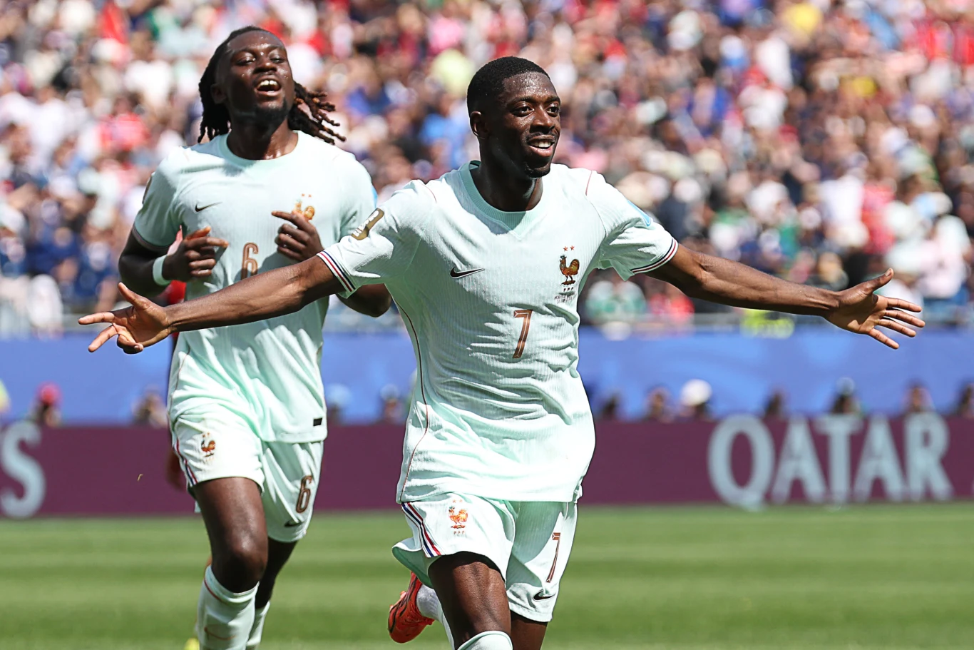 Mundial 2026: Ousmane Dembele pokazał wielką klasę w meczu z Norwegią Piłkarz w jasnym stroju z numerem 7 świętuje zdobycie gola, rozkładając ręce, za nim biegnie kolejny zawodnik tej samej drużyny na tle tłumu kibiców na stadionie.