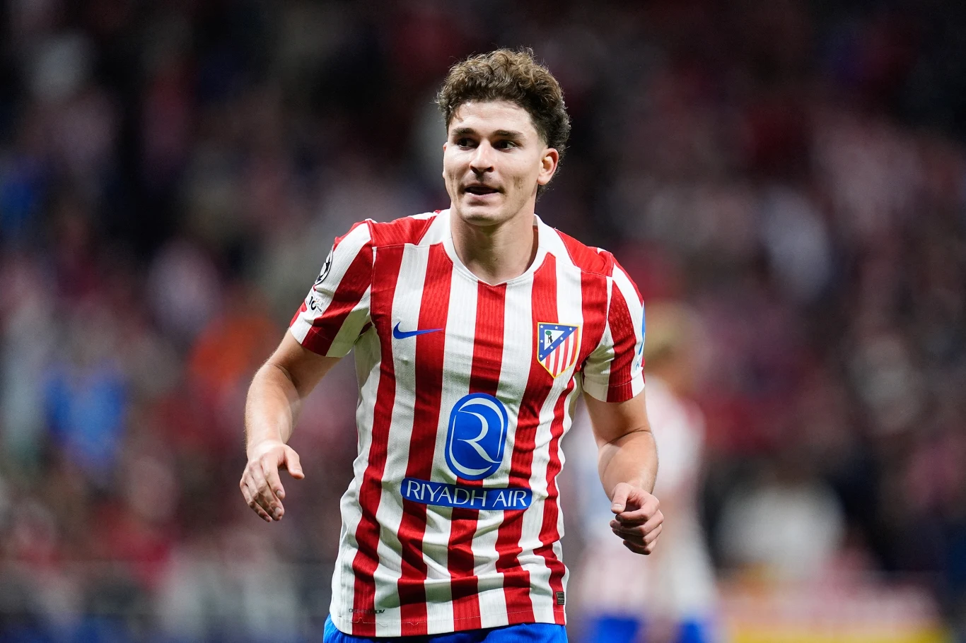 Piłkarz w czerwono-białej koszulce Atlético Madryt w trakcie meczu na stadionie.