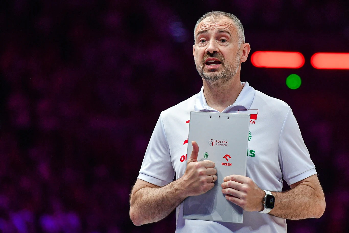 Nikola Grbić ogłosił, że od teraz kadra będzie trenować w 16-osobowym składzie Nikola Grbić w białej koszulce z logo PZPS trzyma tablicę taktyczną podczas meczu na arenie sportowej.