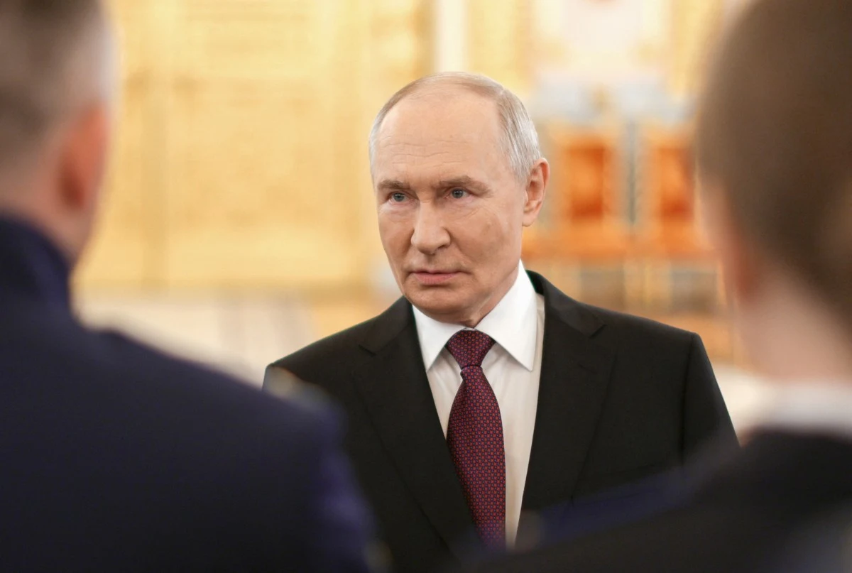 Zdj. ilustracyjne. Władimir Putin podczas jednego z formalnych spotkań w Moskwie Władimir Putin w garniturze i bordowym krawacie podczas formalnego spotkania w Moskwie, jasne tło, złote dekoracje.