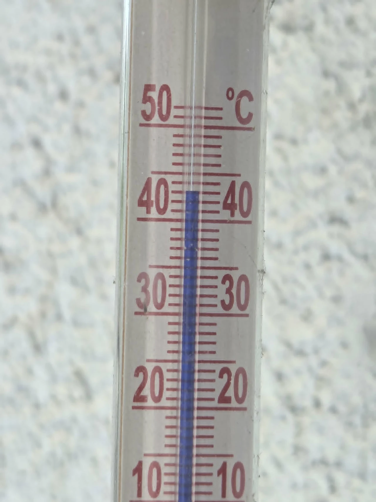 Słup rtęci w termometrze wskazujący temperaturę około 38°C.