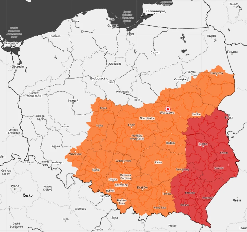 Mapa Polski z wyraźnie zaznaczonymi województwami w dwóch odcieniach: centralna i wschodnia część kraju w kolorze pomarańczowym, a południowo-wschodnie województwa w kolorze czerwonym; widoczne są główne miasta i granice administracyjne.