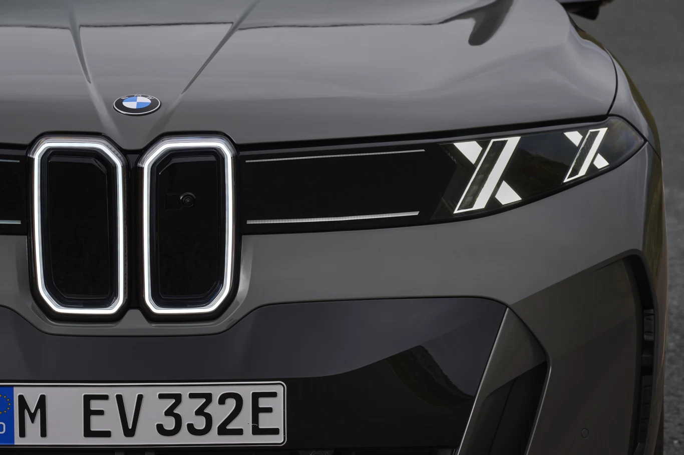 Przód nowoczesnego samochodu marki BMW z charakterystycznymi podwójnymi nerkami w grillu, nowoczesnymi reflektorami LED w kształcie litery X oraz niemiecką tablicą rejestracyjną.