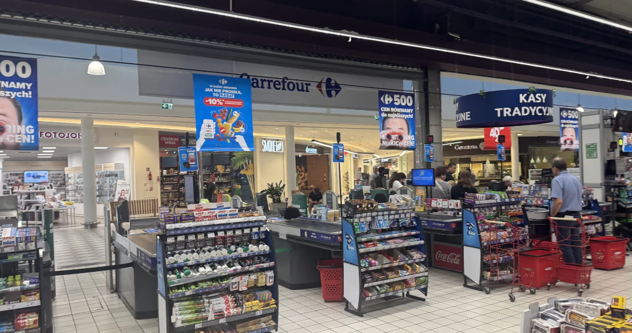 Carrefour rusza z promocjami 2+1, 3+3 i 1+1 za grosz. Na zakupy zostało tylko kilka dni Strefa kas w supermarkecie Carrefour, klienci z czerwonymi koszykami, regały z przekąskami i napojami.