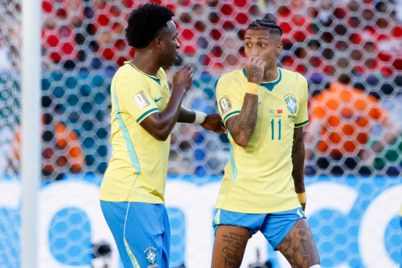 Vinicius Junior i Raphinha w trakcie MŚ 2026 Dwóch piłkarzy reprezentacji Brazylii w żółto-niebieskich strojach rozmawia na boisku podczas meczu piłkarskiego.