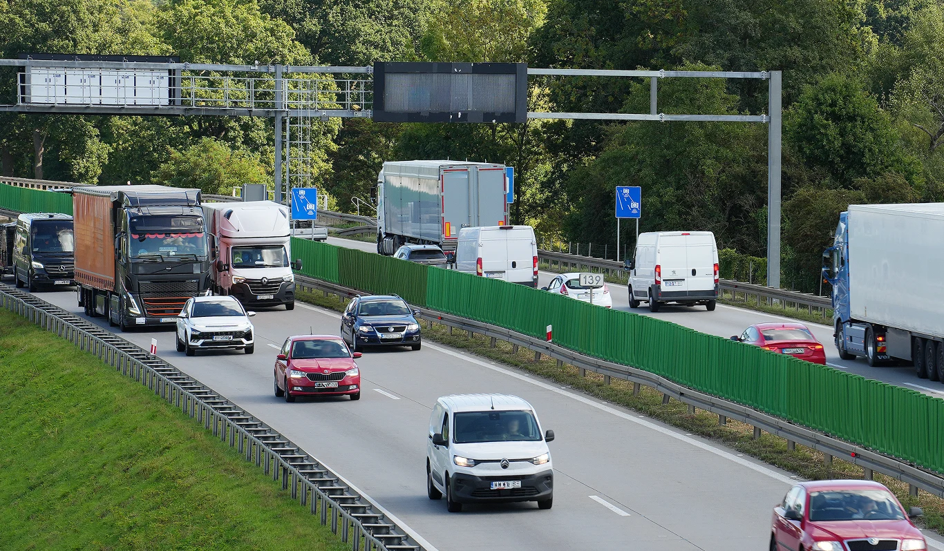 Ruch drogowy nie jest największym zagrożeniem dla jakości powietrza w Polsce Ruch drogowy na autostradzie z samochodami ciężarowymi, dostawczymi i osobowymi obok zielonej bariery dźwiękochłonnej.