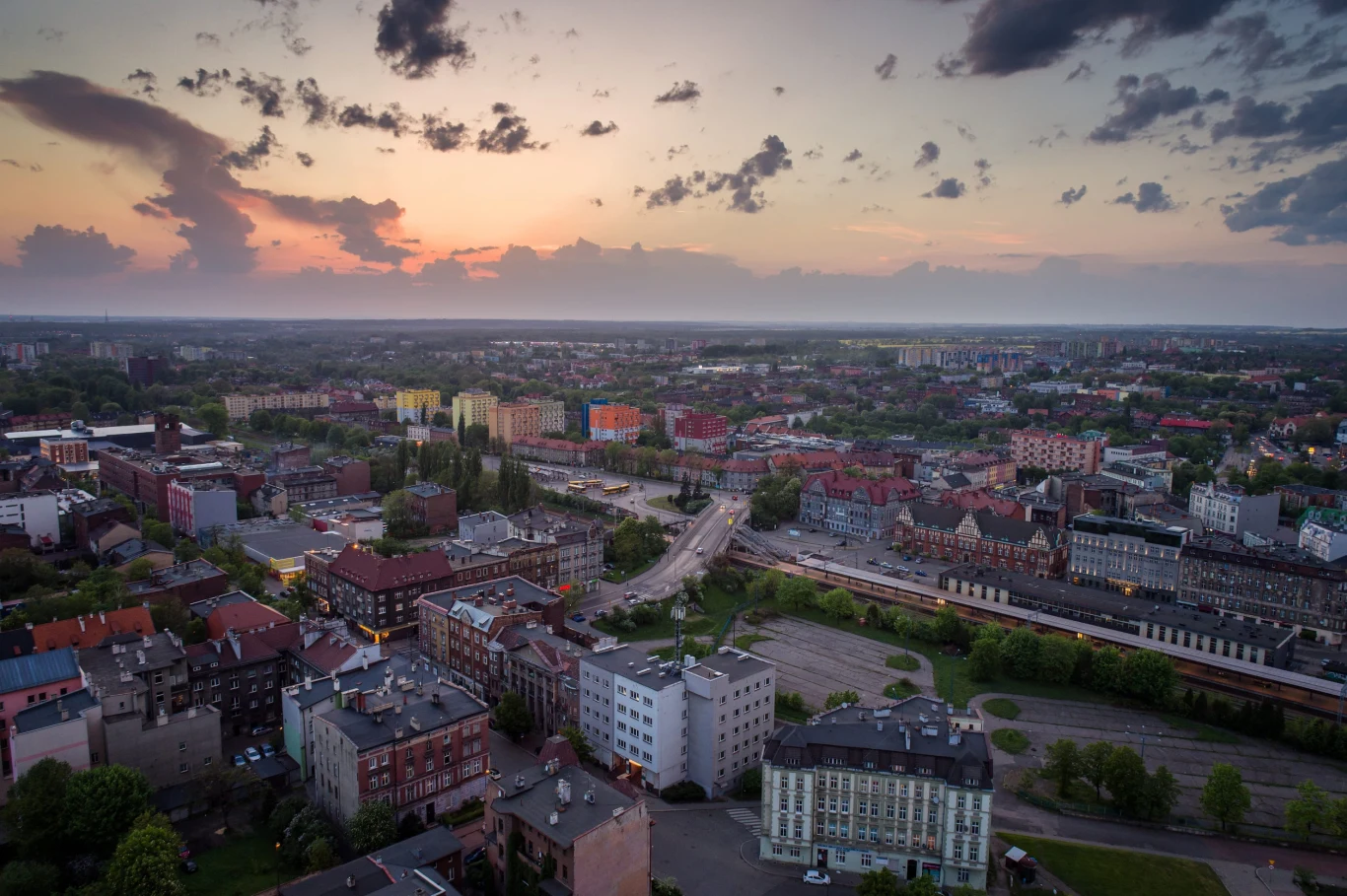 Według lokalnych mediów mieszkańcom Zabrza może zagrażać bomba ekologiczna Panorama Zabrza z niską zabudową, ulicami i dworcem kolejowym przy zachodzie słońca.