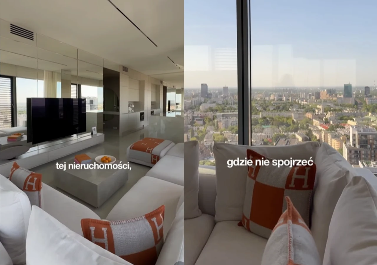 Wnętrza apartamentu na sprzedaż Julii Von Stein Nowoczesny salon z dużymi oknami, jasnymi meblami i designerskimi poduszkami, z których rozciąga się panoramiczny widok na miasto.