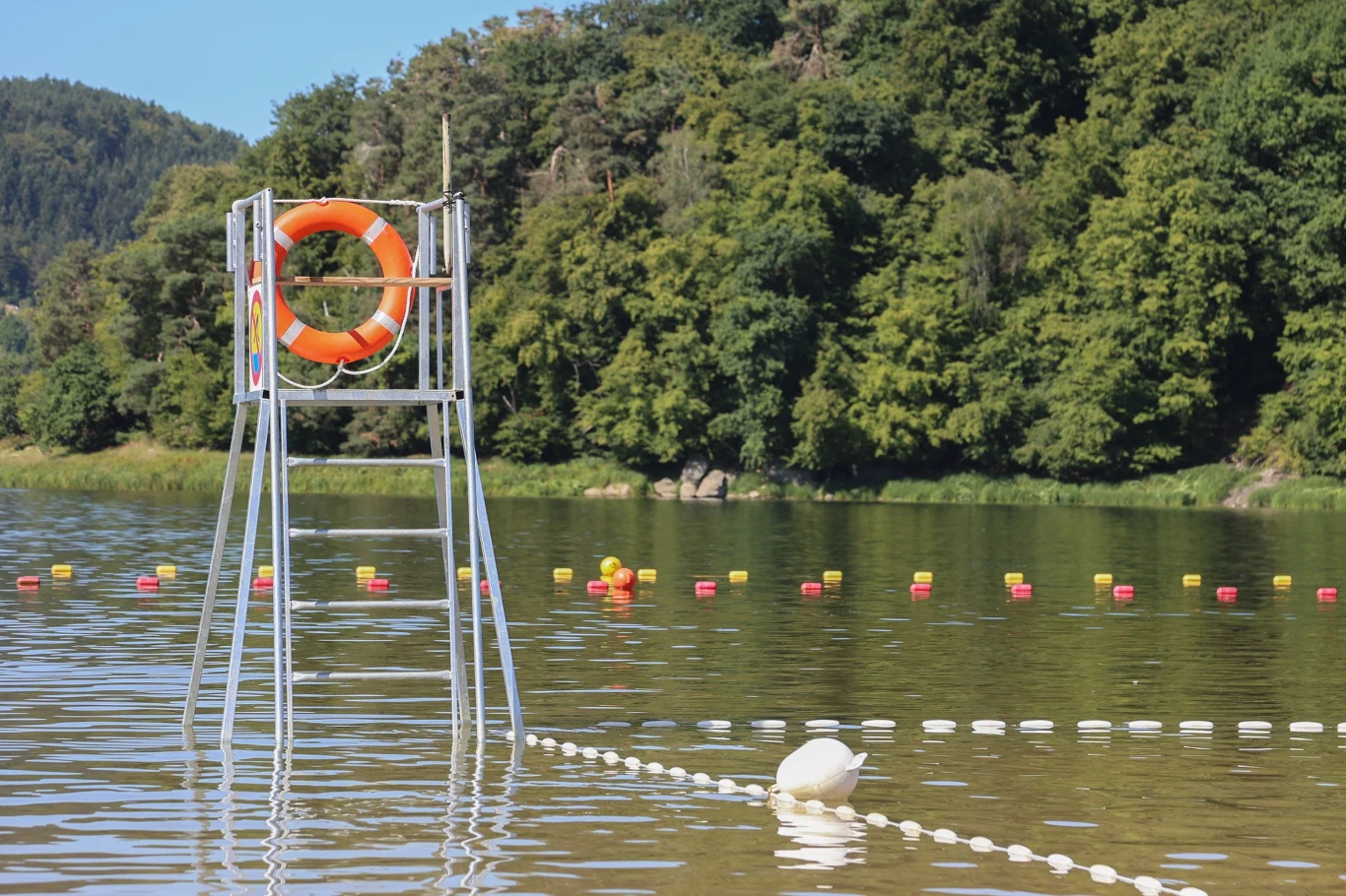 Plaża nad Jeziorem Rożnowskim. Piękne widoki i dobry dojazd z Krakowa. Kąpielisko nad Jeziorem Rożnowskim w Gródku nad Dunajcem. Woda, stanowisko ratownika, las w tle.