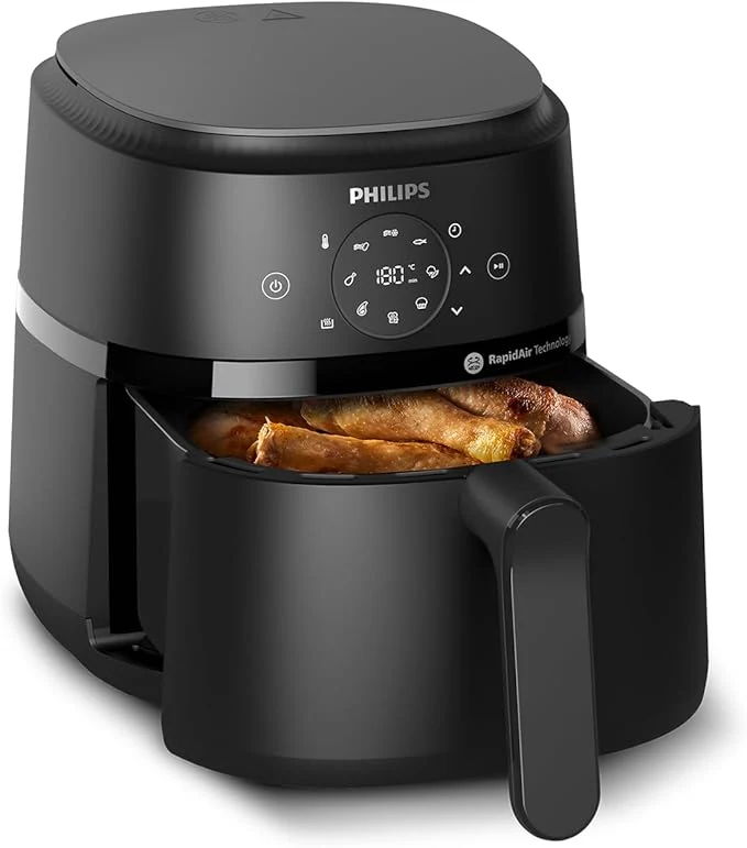 Czarna frytkownica beztłuszczowa marki Philips z wysuniętą szufladą, w której znajdują się upieczone kawałki kurczaka.