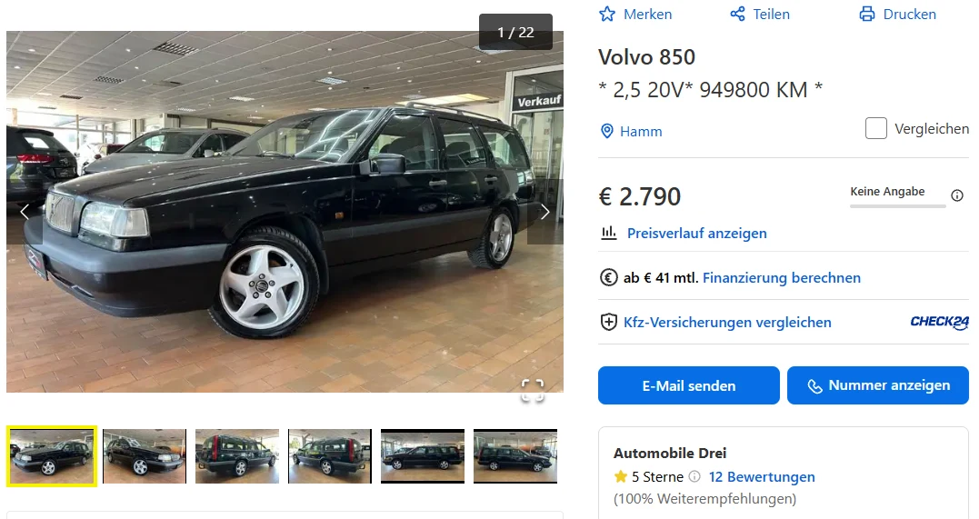 Czarny Volvo 850 kombi stoi w salonie samochodowym na tle przeszklonych ścian, zestawiony z innymi autami po lewej stronie, widoczne są srebrne alufelgi oraz czyste, zadbane nadwozie.