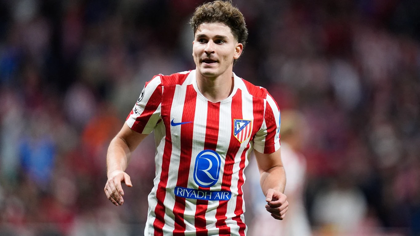 Piłkarz w czerwono-białej koszulce Atletico Madryt biegnie po murawie stadionu podczas meczu, skoncentrowany i pełen energii.