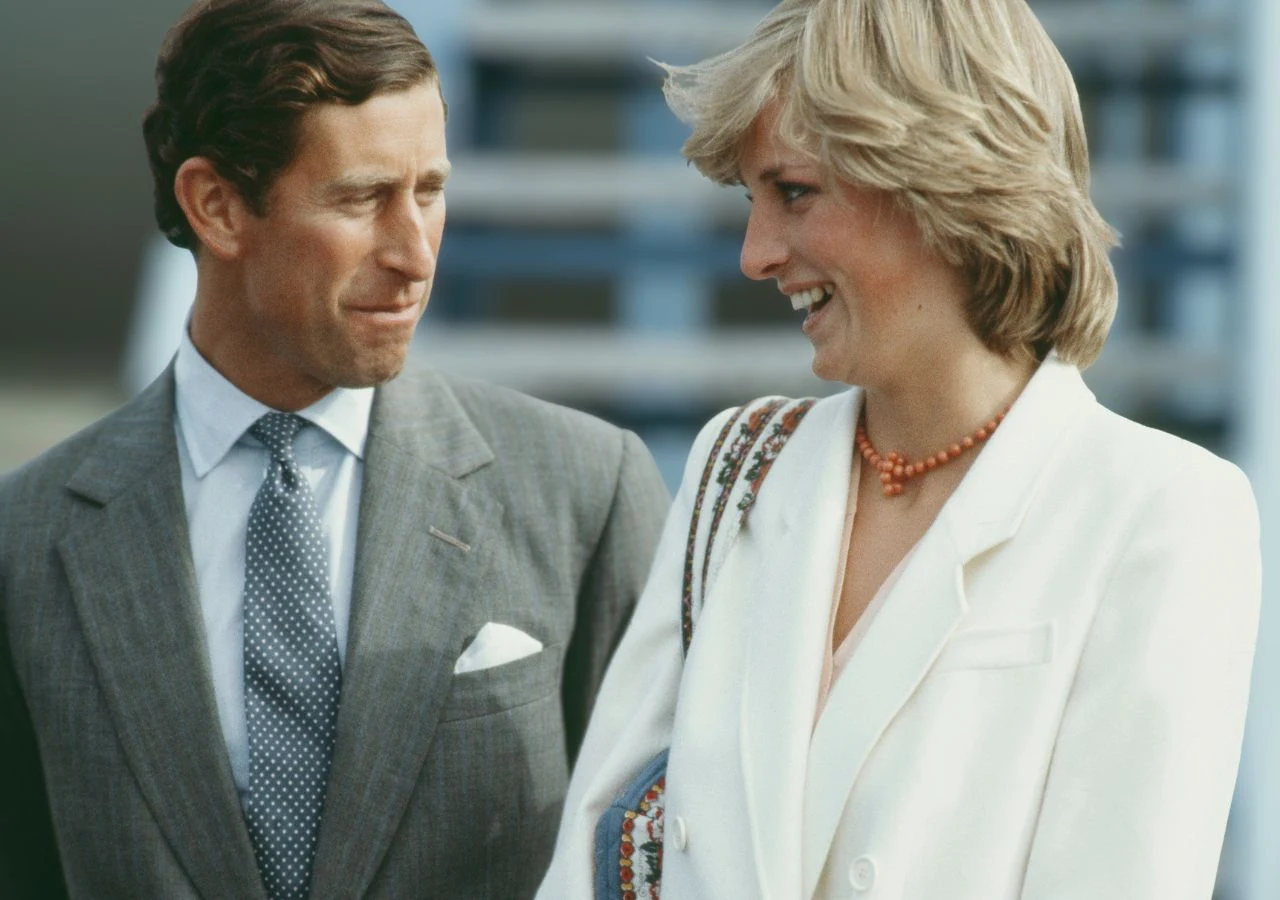 Karol i księżna Diana wracają z podróży poślubnej do Szkocji we wrześniu 1981 Książę Karol w szarym garniturze i księżna Diana w białej marynarce w 1981 roku, po powrocie z rejsu poślubnego.