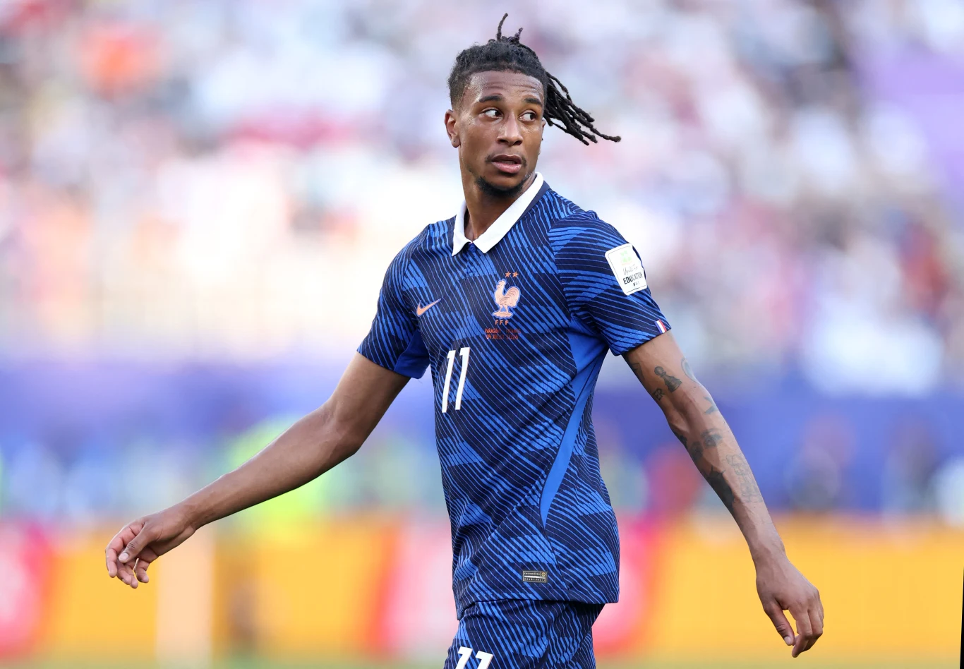 Michael Olise Piłkarz w niebieskiej koszulce reprezentacji Francji z numerem 11 podczas meczu na stadionie.