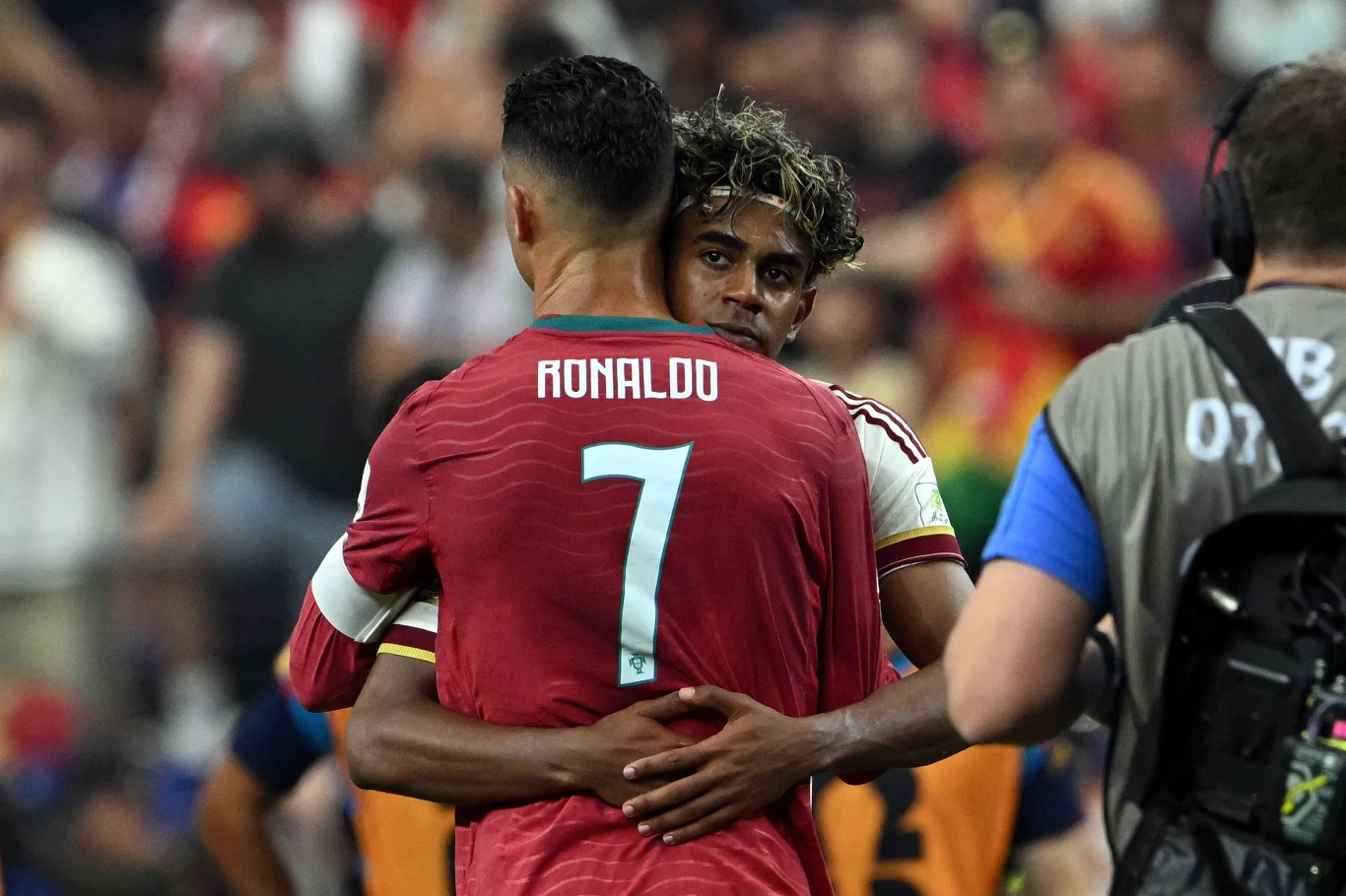Dwóch piłkarzy obejmuje się na boisku, jeden z nich ma na plecach nazwisko Ronaldo i numer 7 na czerwonej koszulce.