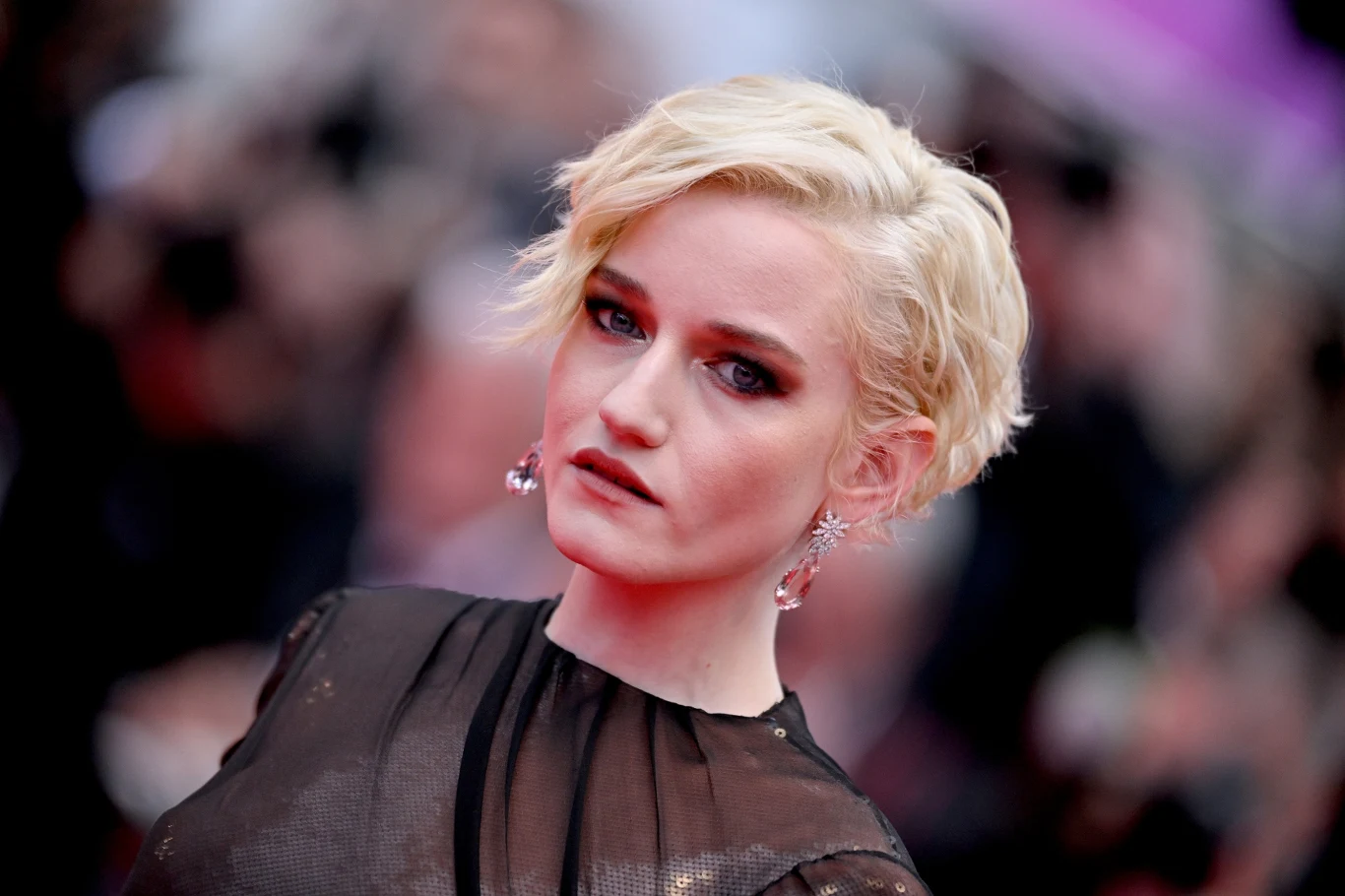 Julia Garner Aktorka Julia Garner w czarnej kreacji wieczorowej, ciemnym makijażu i zaczesanych włosach.