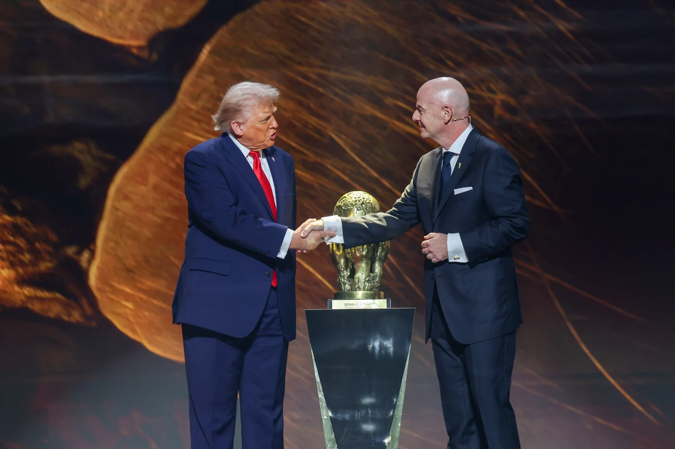 Donald Trump (po lewej) i Gianni Infantino (po prawej) Donald Trump i Gianni Infantino ściskają dłonie przy Pucharze Świata FIFA.