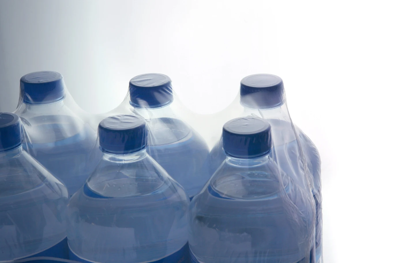 Wielopaki wody nie zostaną zakazane przez UE. Unia chce tylko ograniczyć ilość plastiku w opakowaniach Zgrzewka sześciu dużych plastikowych butelek wody mineralnej owinięta przezroczystą folią.