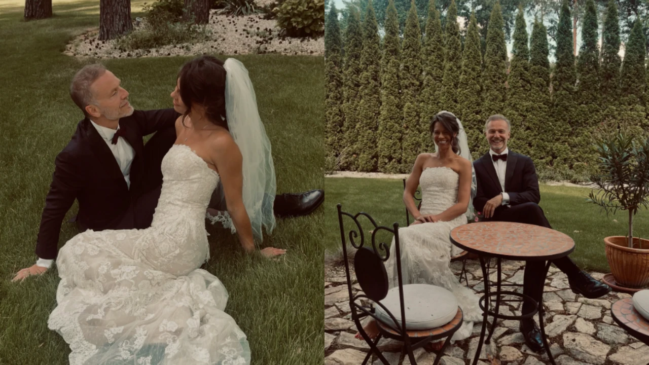 Para młoda ubrana w eleganckie stroje ślubne – mężczyzna w czarnym garniturze z muszką i kobieta w białej, koronkowej sukni z welonem – siedzi razem najpierw na trawie, a następnie przy okrągłym stole w ogrodzie na tle wysokich zielonych krzewów.