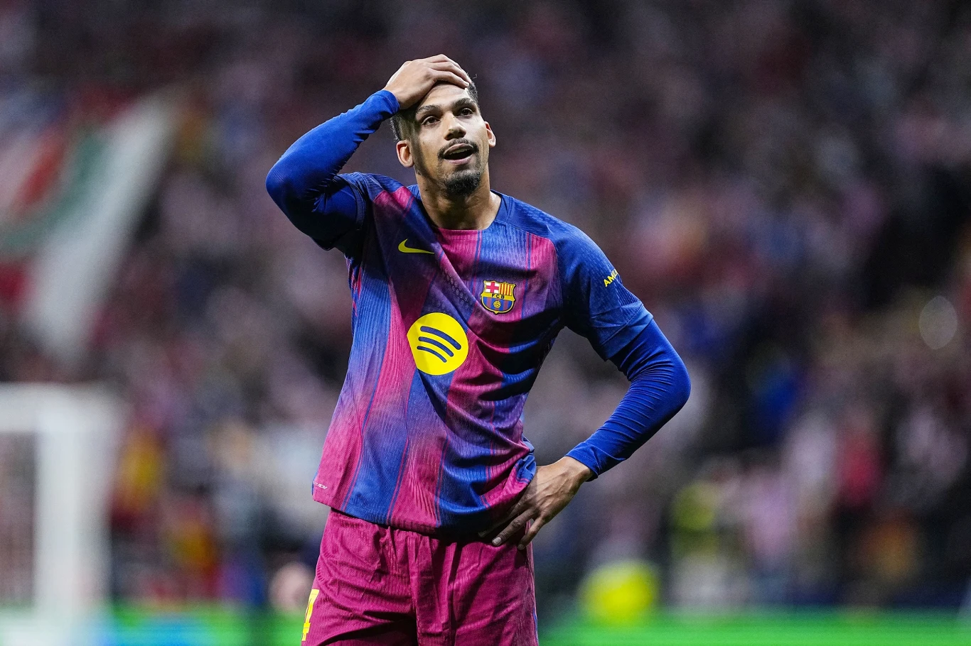Ronald Araujo Piłkarz FC Barcelony w niebiesko-różowym stroju trzyma dłoń na głowie i wygląda na zmartwionego podczas meczu.
