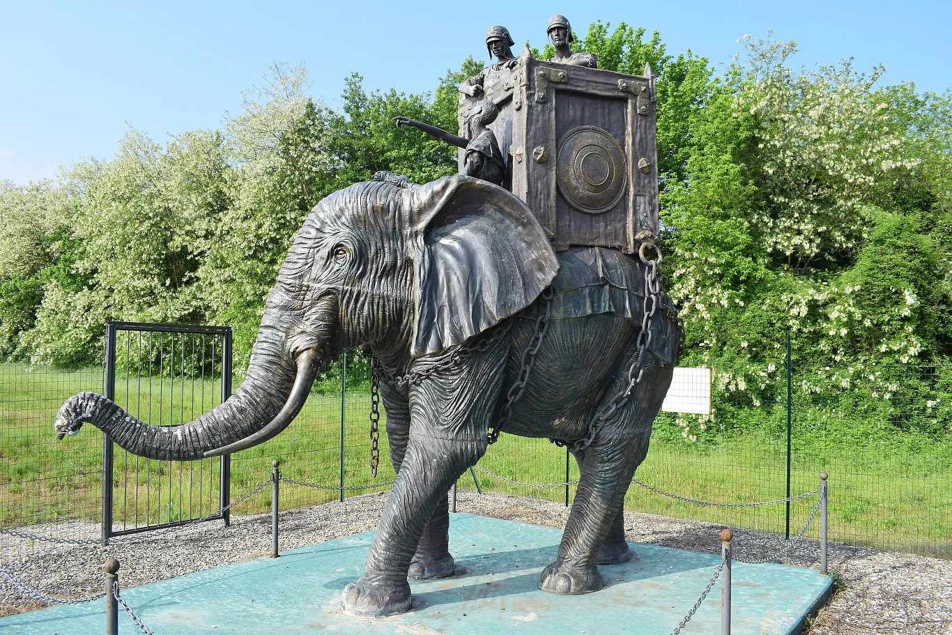 Pomnik upamiętniający bitwę pod Trebią z 218 r. p.n.e., przedstawiający kartagińskiego słonia bojowego. Monumentalna rzeźba słonia bojowego z platformą obronną na grzbiecie oraz dwiema postaciami żołnierzy przygotowanych do walki, otoczona niskim ogrodzeniem i zielenią.
