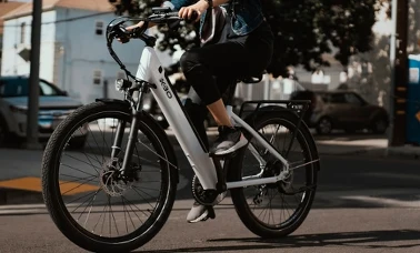 Miejski rower elektryczny z białą ramą na ulicy w słoneczny dzień