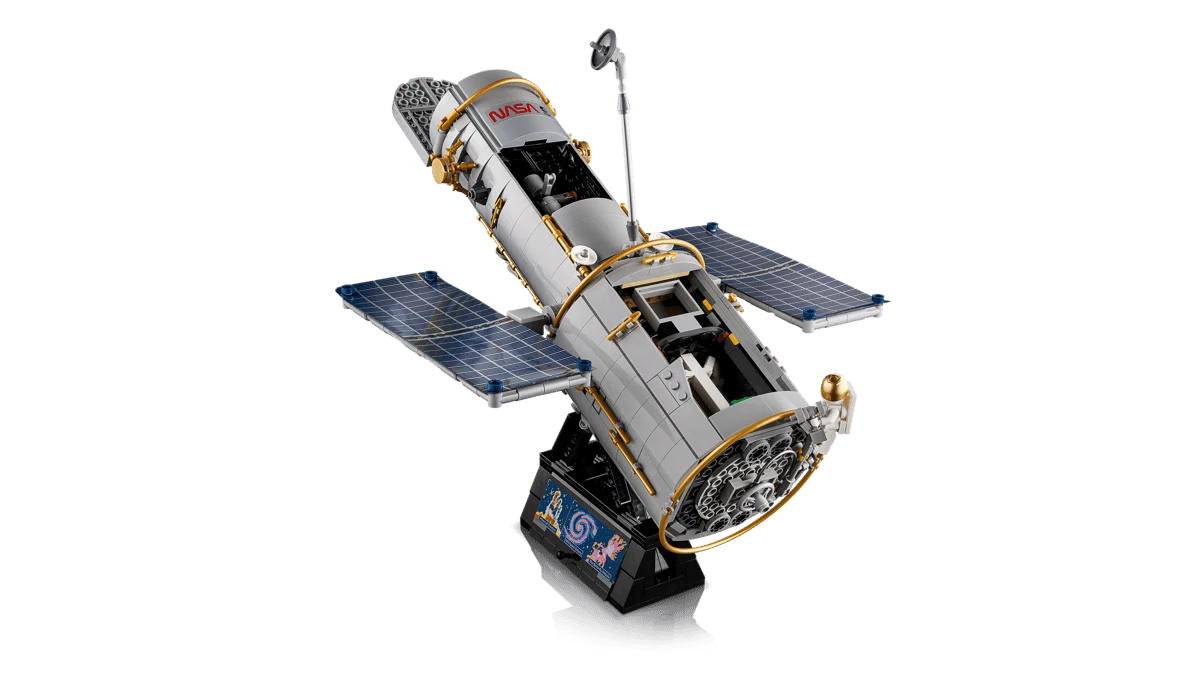 Kosmiczny Teleskop Hubble'a to zestaw LEGO składający się z 1252 klocków. Model teleskopu kosmicznego z wyraźnie widocznymi panelami słonecznymi oraz detalami konstrukcyjnymi, umieszczony na czarnej podstawce z ozdobną grafiką.