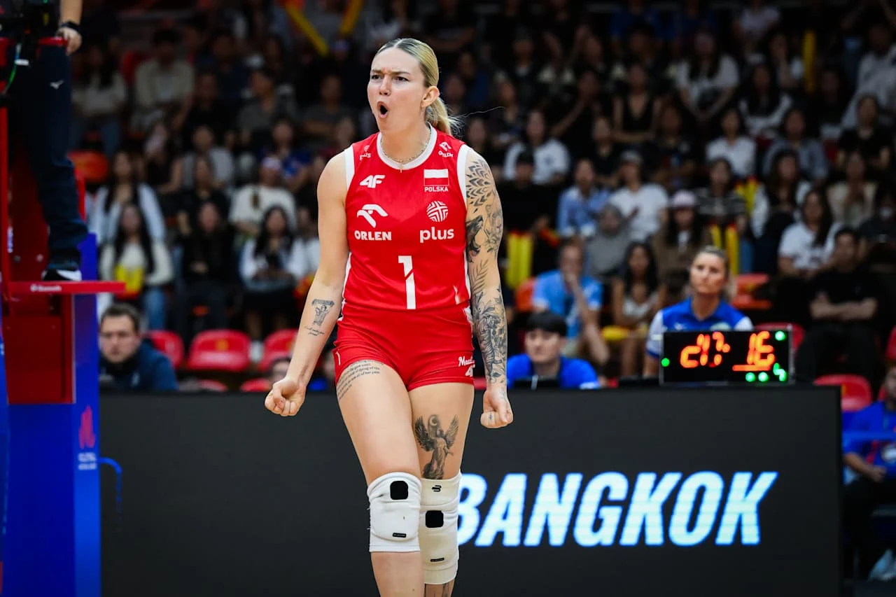 Julia Szczurowska Zawodniczka polskiej reprezentacji siatkówki w czerwonym stroju z numerem 1 na koszulce, wyrażająca silne emocje po udanej akcji na tle trybun i tablicy z napisem 'Bangkok'.