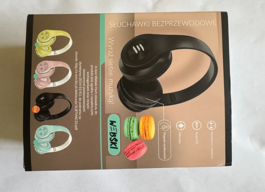 Czarne, bezprzewodowe słuchawki nauszne marki W-EBSKI na opakowaniu, obok kolorowych makaroników i ikon przedstawiających główne funkcje produktu, takich jak Bluetooth, mikrofon i długi czas pracy na baterii.