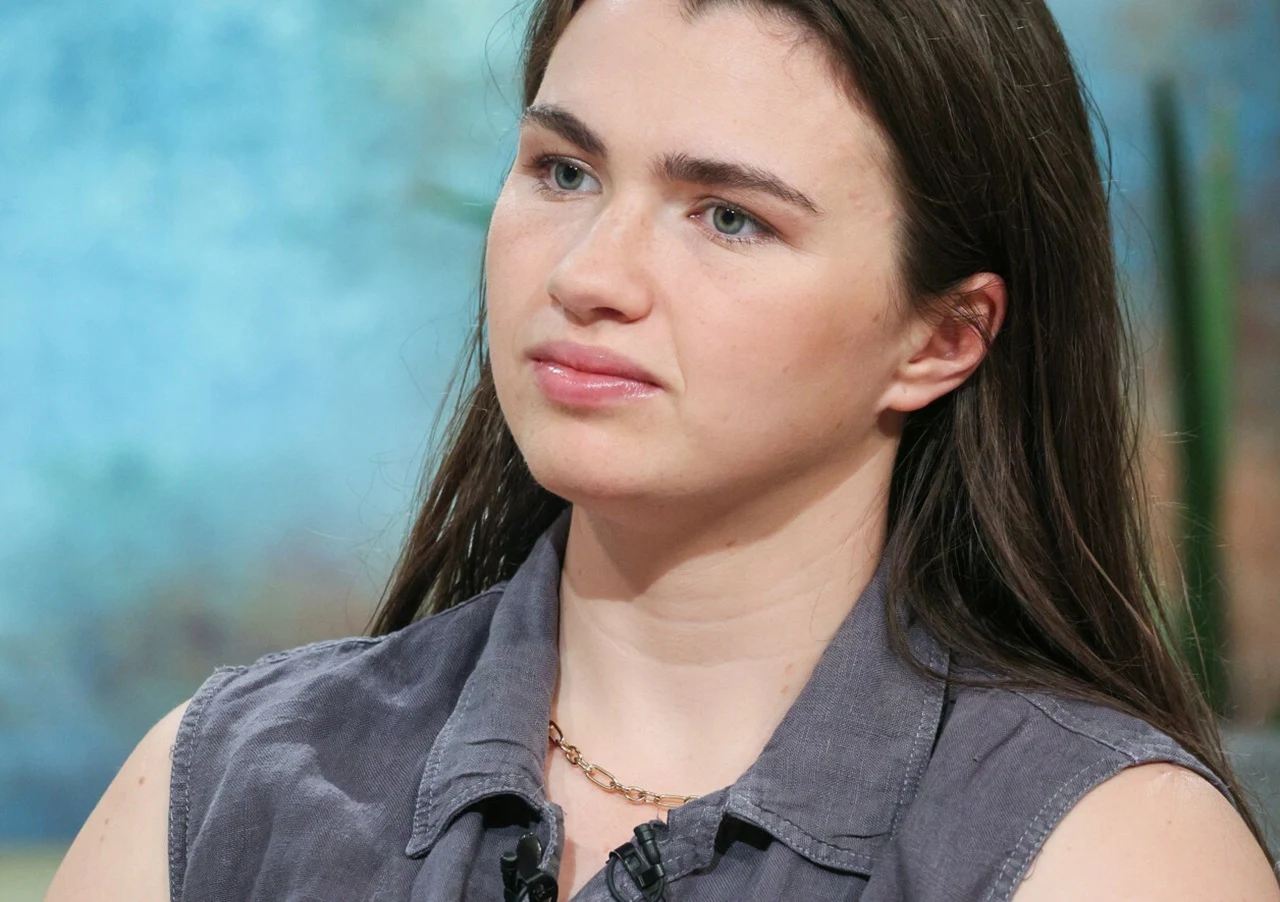 Julia Walczak Julia Walczak w szarej koszuli bez rękawów pozuje w jasnym wnętrzu.