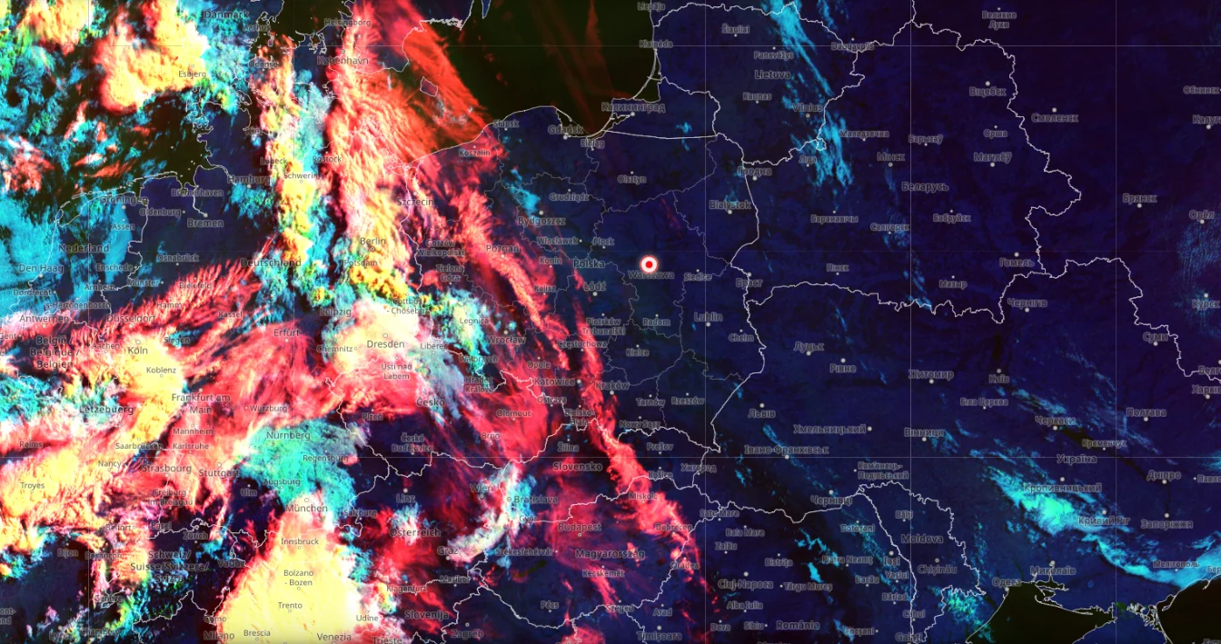 Burzowe zjawiska zaczną się na zachodzie wczesnym popołudniem, a największą skalę osiągną pod koniec dnia Kolorowy obraz satelitarny z wyraźnie zarysowaną granicą atmosferycznych frontów burzowych przesuwających się znad Niemiec w kierunku Polski, z intensywnymi, gęstymi chmurami oraz wyświetlonymi nazwami miast i granicami krajów centralnej Europy.