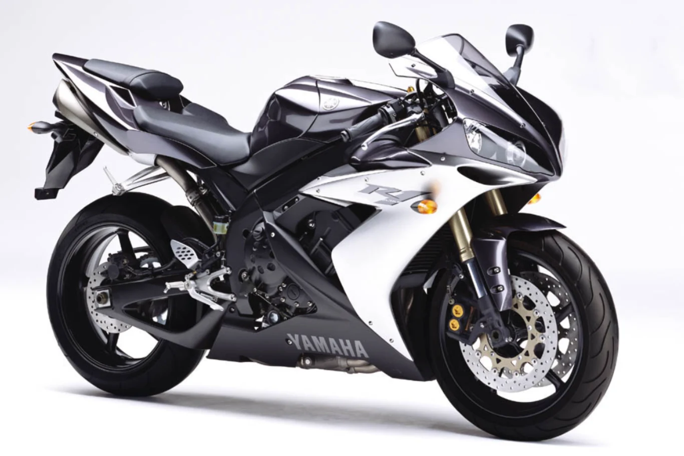 Czarny motocykl sportowy marki Yamaha o aerodynamicznej sylwetce, masywnym przednim widelcu i charakterystycznych tarczach hamulcowych na białym tle.