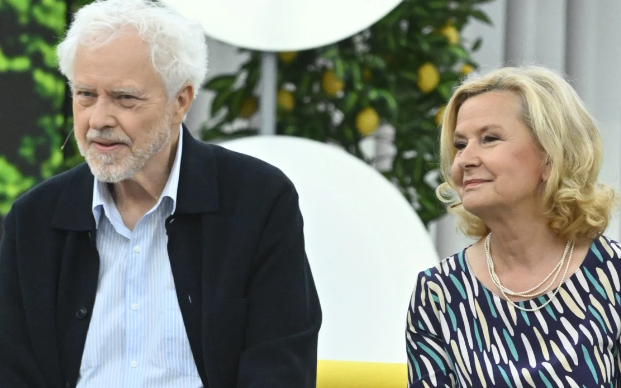 Barbara i Jacek Bursztynowiczowie Starsza kobieta i starszy mężczyzna siedzą obok siebie, patrząc w jednym kierunku, oboje elegancko ubrani, w tle roślina z żółtymi cytrynami.