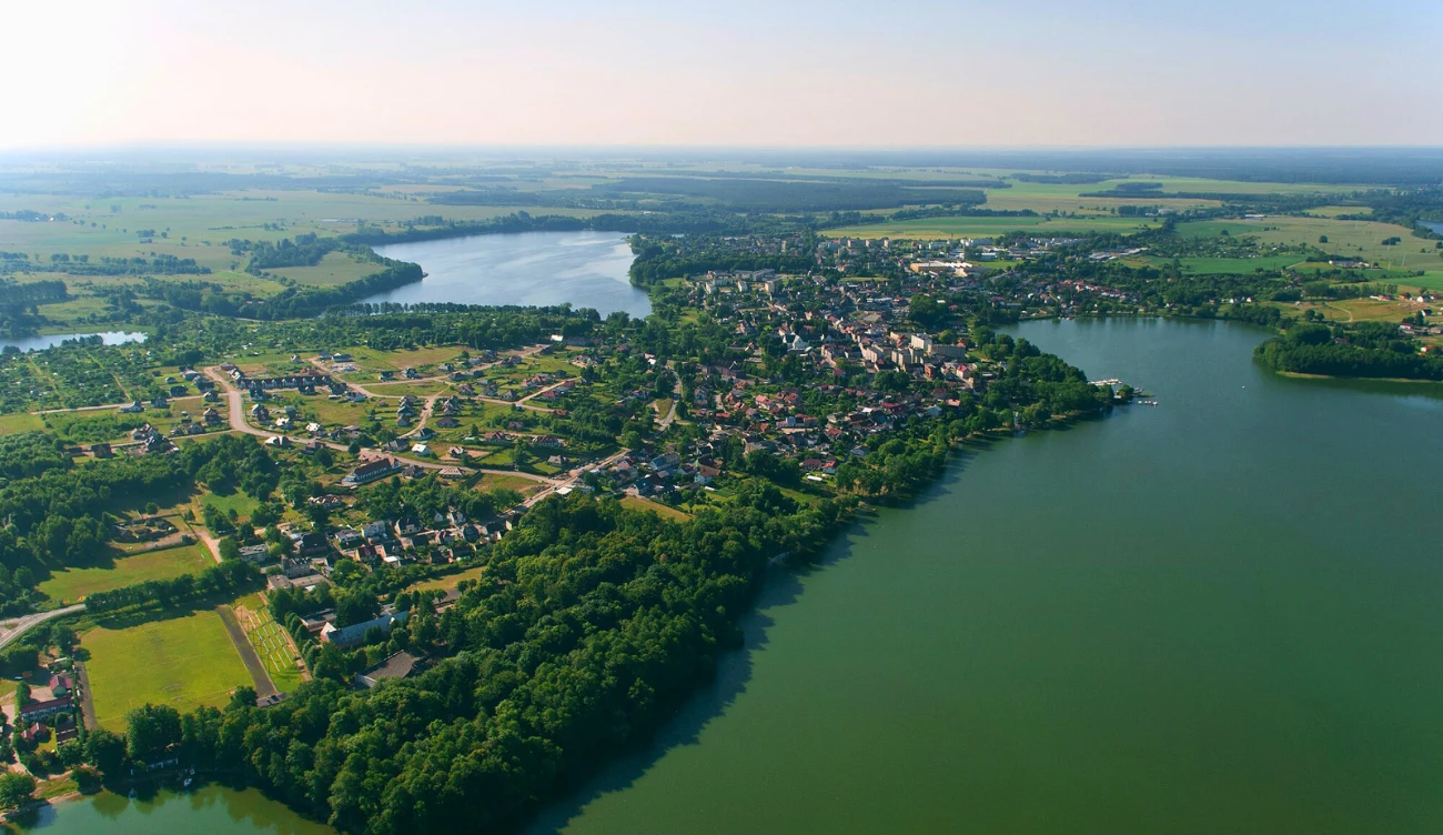 Gdzie znajduje się jezioro Drawsko? Panorama Czaplinka nad jeziorem Drawsko, otoczonego zielenią, polami uprawnymi i zabudową przy brzegu.